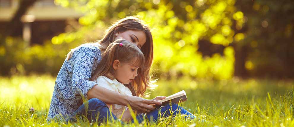 Famille en train de lire en extérieur